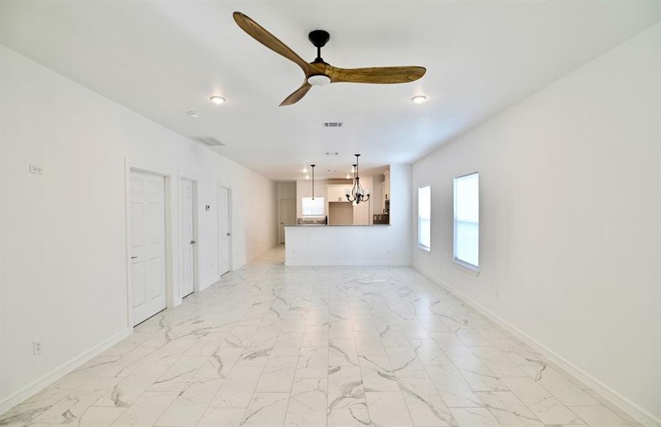 Unfurnished living room featuring light tile patterned floors and ceiling fan