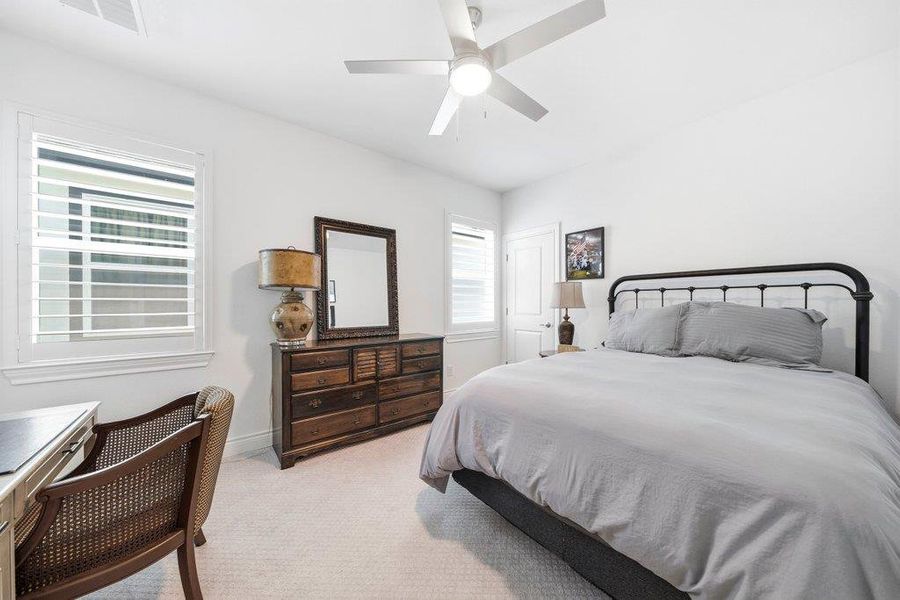 Plentiful natural light filters through plantation shutters into this comfortable bedroom with soft carpeting. Plentiful natural light filters through plantation shutters into this comfortable bedroom with soft carpeting.