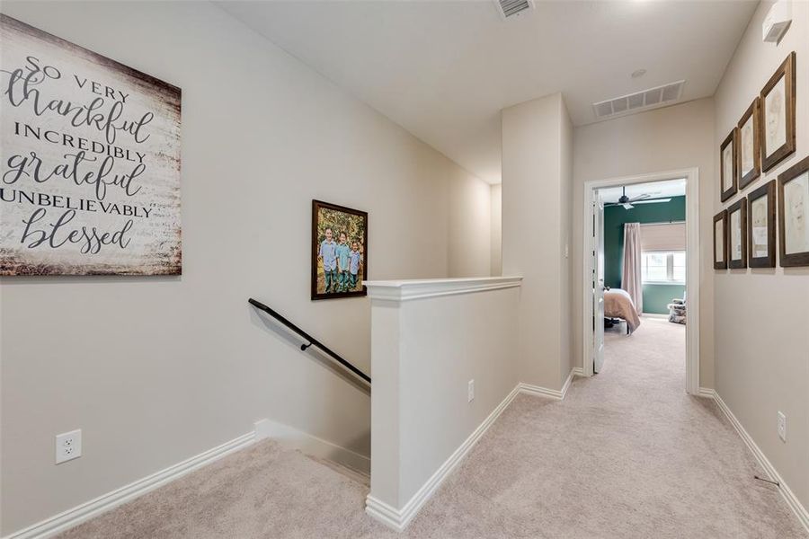 Corridor with an upstairs landing and carpet