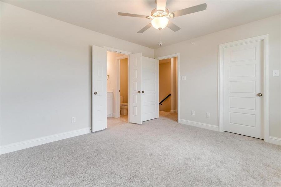 Unfurnished bedroom featuring ceiling fan and light carpet