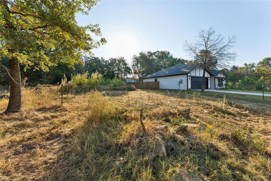 View of yard with view of wooded area and an outbuilding