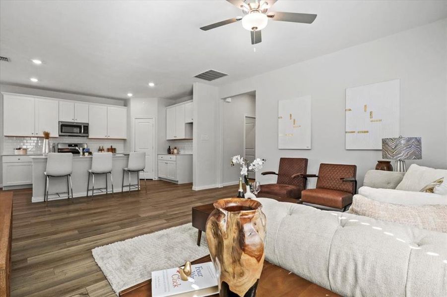 Living room featuring recessed lighting, dark wood-style flooring, and a ceiling fan Living room featuring recessed lighting, dark wood-style flooring, and a ceiling fan