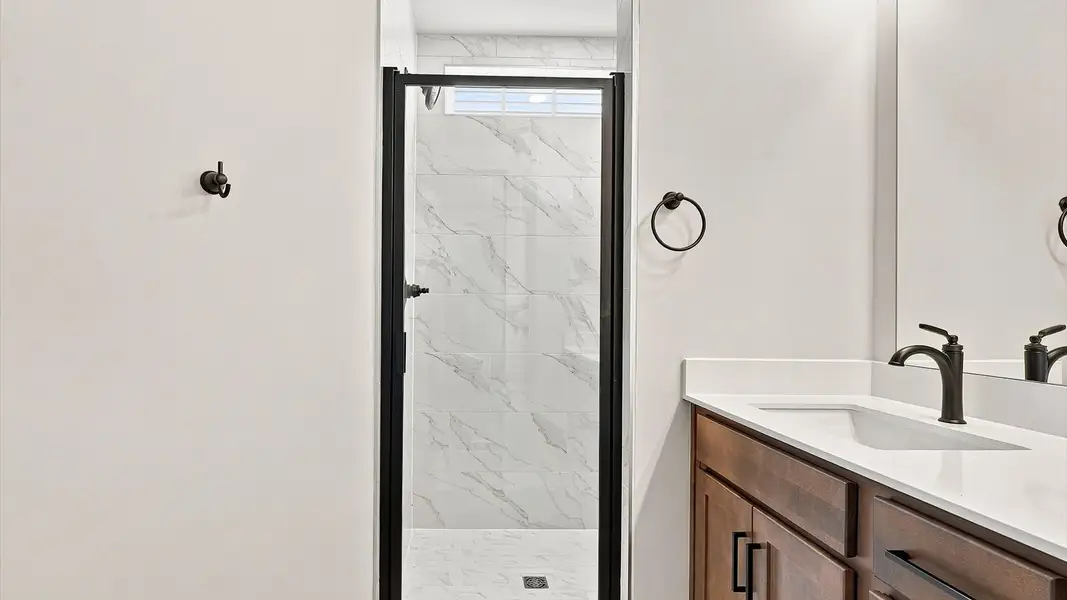 Notable primary bath featuring a walk-in shower and tasteful design touches throughout by DRB Homes
