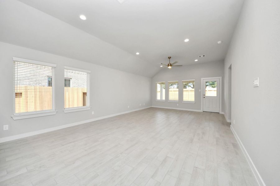 Relax and unwind in this inviting family room, illuminated by abundant natural light streaming in through tall windows, complemented by high ceilings and stunning flooring. Stay comfortable year-round with the gentle breeze from the ceiling fan, creating the perfect atmosphere for family gatherings. Sample photo of completed home with similar floor plan. Actual colors and selections may vary.