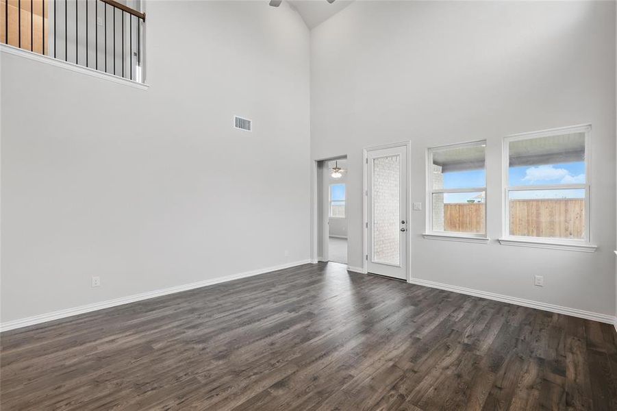 Foyer entrance with dark wood-type flooring, a ceiling fan, and a high ceiling