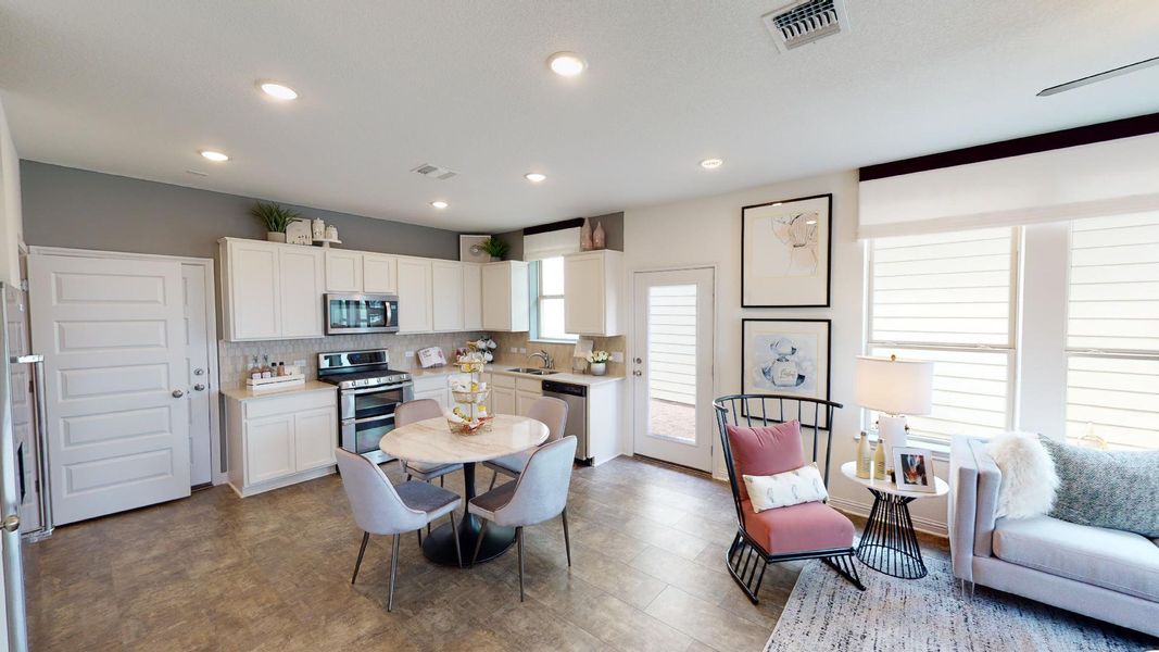 Kitchen with light countertops, stainless steel appliances, white cabinets, tasteful backsplash, and recessed lighting