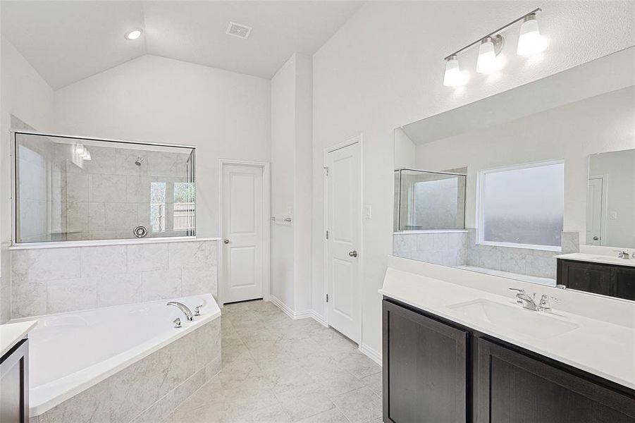 Bathroom with vanity, plus walk in shower, and lofted ceiling