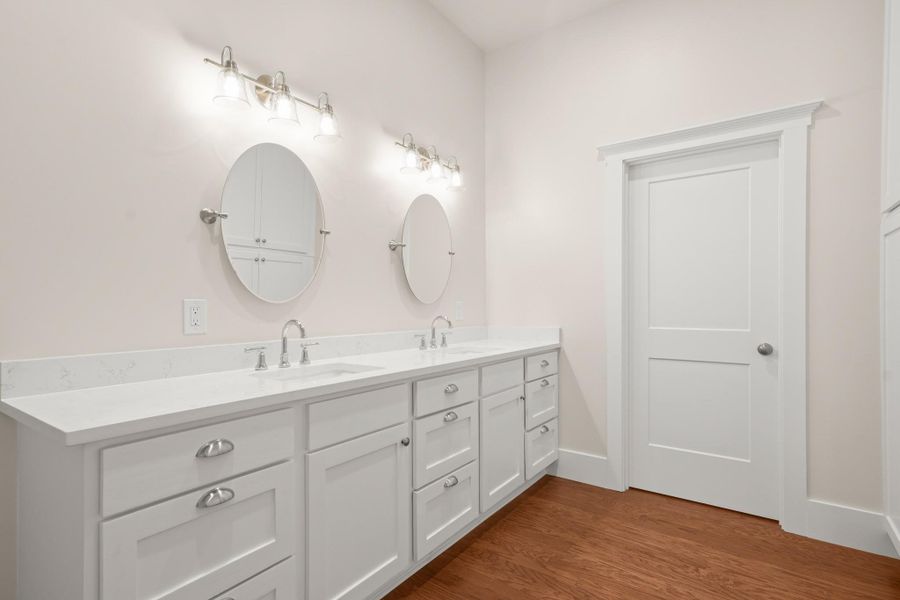 Double vanities with sleek countertops elevate this well-appointed bath space. Double vanities with sleek countertops elevate this well-appointed bath space.