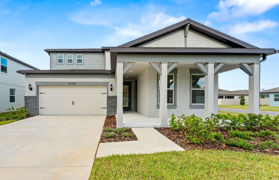 Front exterior of a new home in Riverwood, Zephyrhills, FL, highlighting curb appeal (Image 2). Front exterior of a new home in Riverwood, Zephyrhills, FL, highlighting curb appeal (Image 2).