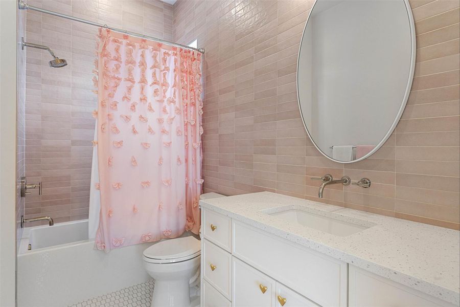 Full bath featuring tile walls, shower / bathtub combination with curtain, vanity, and tile patterned flooring
