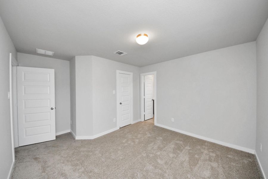 Secondary bedroom features plush carpeting, large windows that let in plenty of natural light, bright paint, and spacious closets. Sample photo of completed home with similar floor plan. Actual colors and selections may vary.