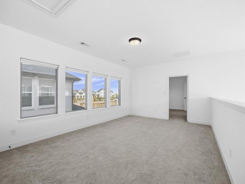 Upstairs Game room with light colored carpet and baseboards Upstairs Game room with light colored carpet and baseboards