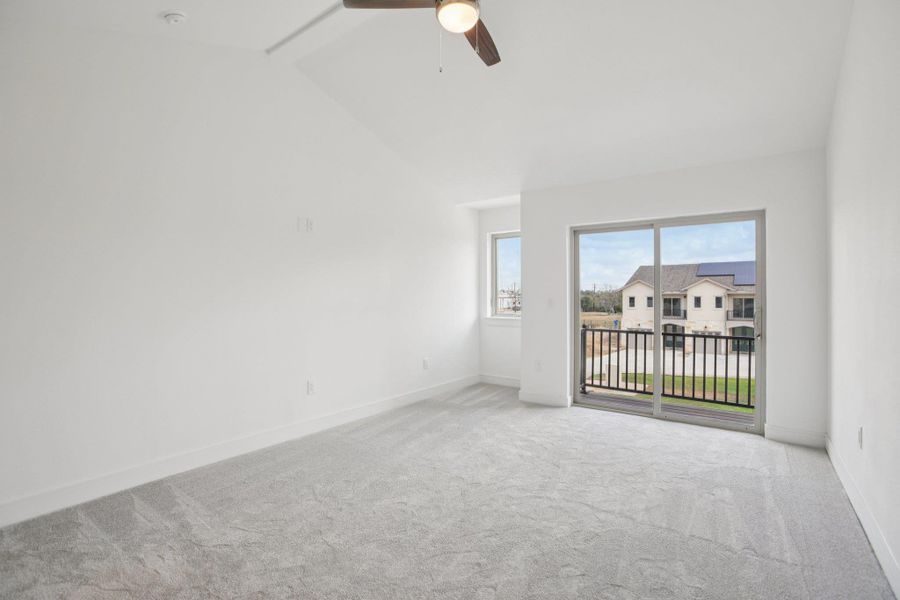 Spare room with light colored carpet, a ceiling fan, and vaulted ceiling