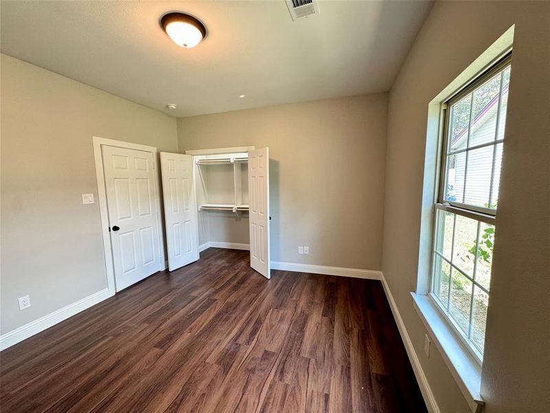 Unfurnished bedroom with dark wood-type flooring