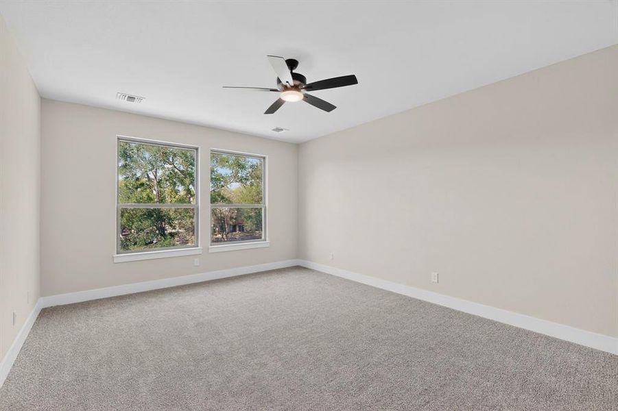 Spacious room featuring neutral paint, light gray carpet, and two large windows