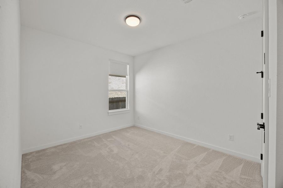 Empty room featuring baseboards and light colored carpet