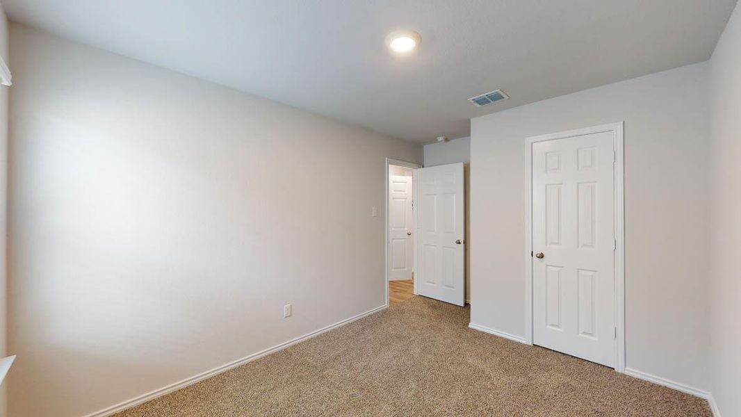 Carpeted room with light neutral wall paint, white trim, and a white six-panel door