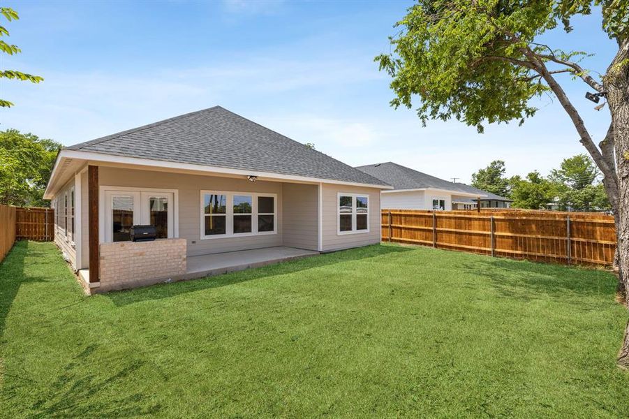 Rear view of house with a patio area and a yard