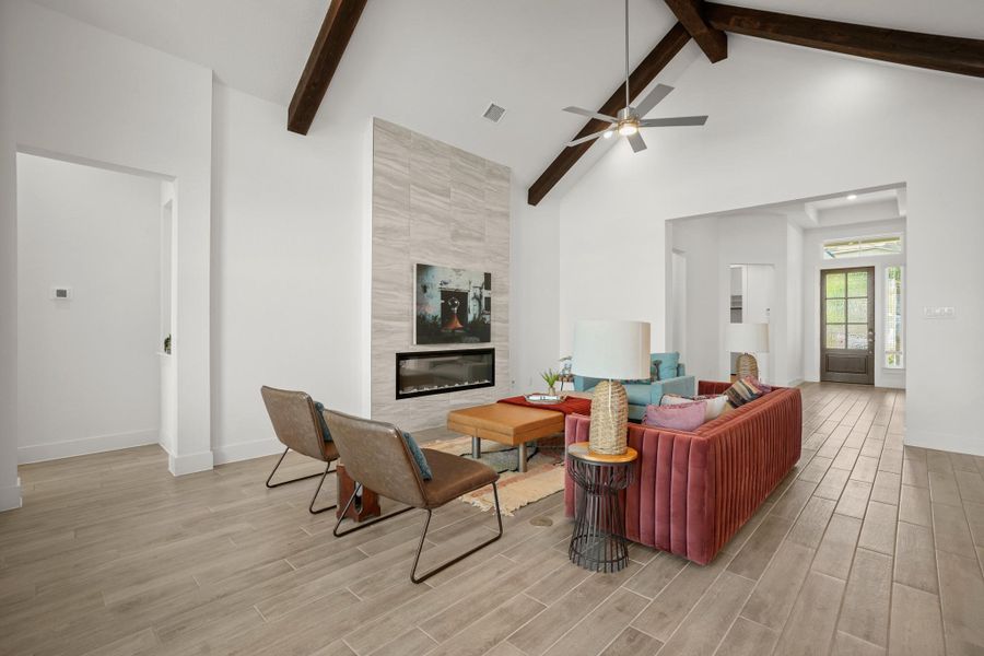 Exposed wood beams accentuate soaring vaulted ceilings in this generously proportioned living area.