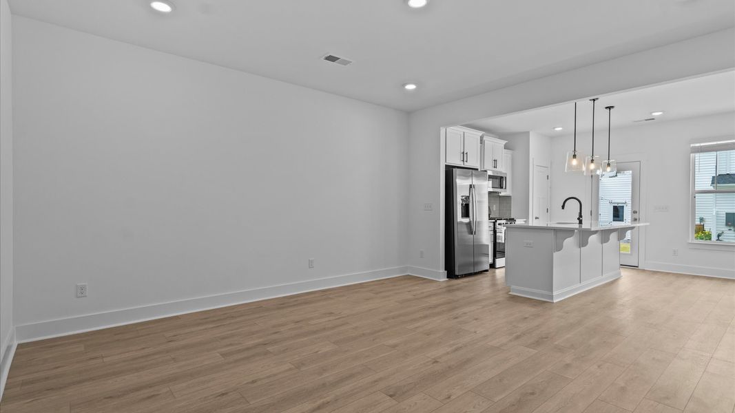 Spacious family room with rich hardwood flooring and elegant trim work in a reputable DRB Homes build Spacious family room with rich hardwood flooring and elegant trim work in a reputable DRB Homes build