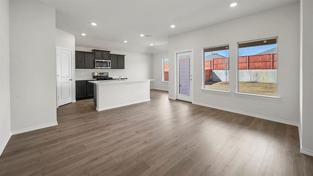 Kitchen featuring a kitchen island with sink, dark wood-style flooring, appliances with stainless steel finishes, recessed lighting, and open floor plan