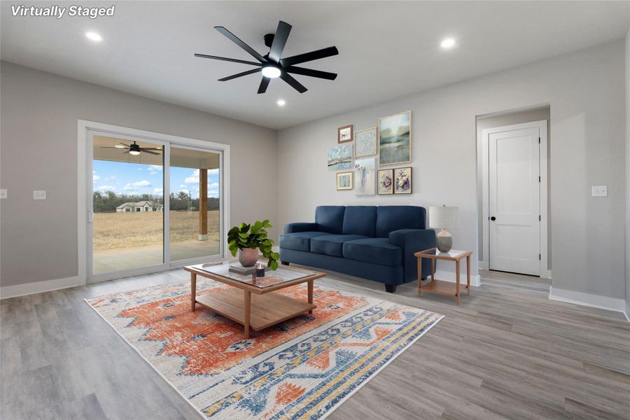 Living room featuring light wood-style flooring, ceiling fan, and recessed lighting