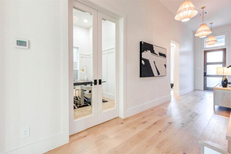 An alternate view of the study showcases the elegant glass French doors and seamless flow into the main hall.