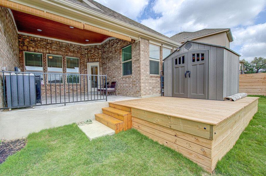 An expansive wooden deck and covered concrete patio overlook the grassy backyard. An expansive wooden deck and covered concrete patio overlook the grassy backyard.