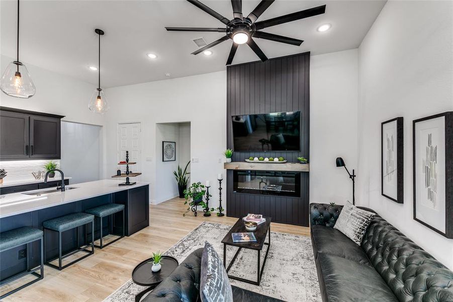 Living room with ceiling fan, fireplace, wood-style flooring