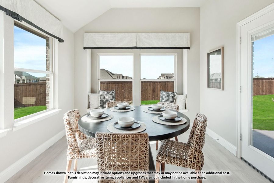 Bright breakfast nook with round dark table, woven chairs, built-in bench seating, and large windows overlooking backyard Bright breakfast nook with round dark table, woven chairs, built-in bench seating, and large windows overlooking backyard