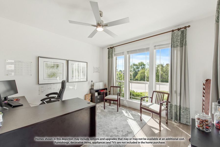 Home office with dark wood desk, ceiling fan, and large windows with natural light Home office with dark wood desk, ceiling fan, and large windows with natural light