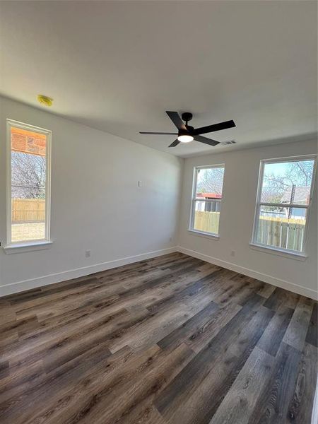 Bedroom 2 featuring dark wood finished w/ floors, healthy amount of natural light, and a ceiling fan