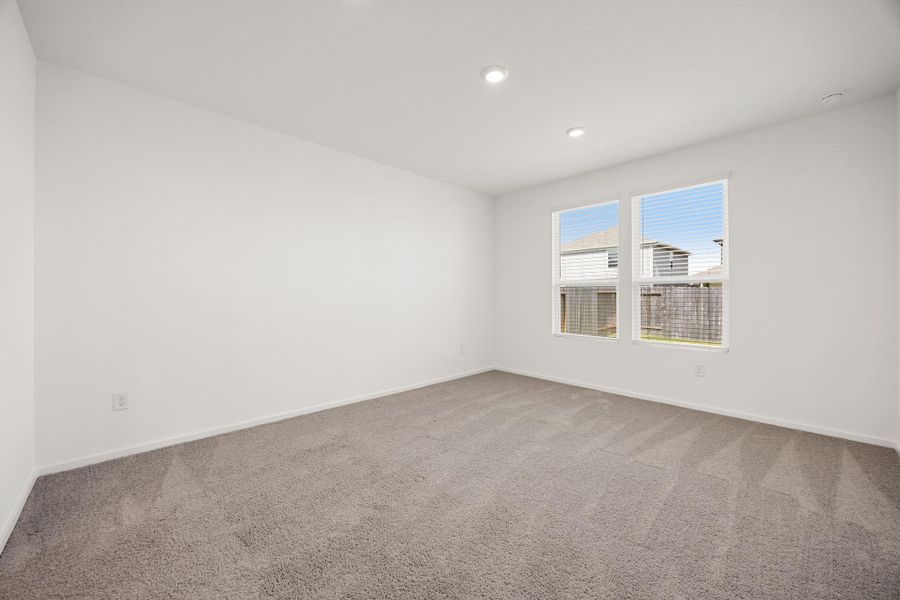 Retreat to the spacious first-floor primary suite, offering plenty of room for a king-sized bed and additional furnishings. Large windows fill the space with natural light, creating a peaceful and relaxing atmosphere at the end of the day.