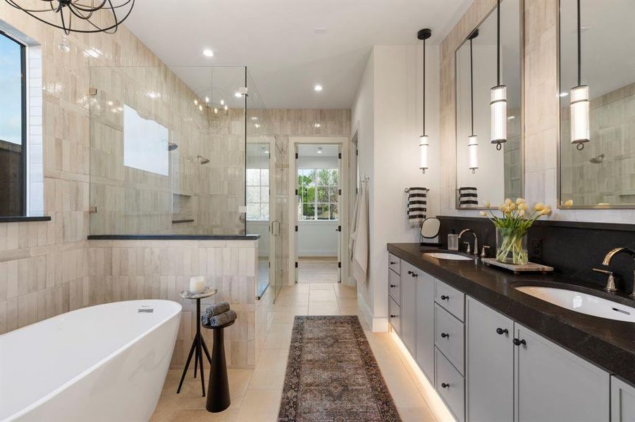 Full bathroom with tile walls, double vanity, a shower stall, a freestanding tub, and light tile patterned floors Full bathroom with tile walls, double vanity, a shower stall, a freestanding tub, and light tile patterned floors