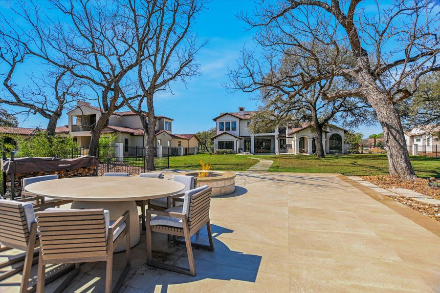 View of patio featuring outdoor dining area, an outdoor fire pit, and a residential view