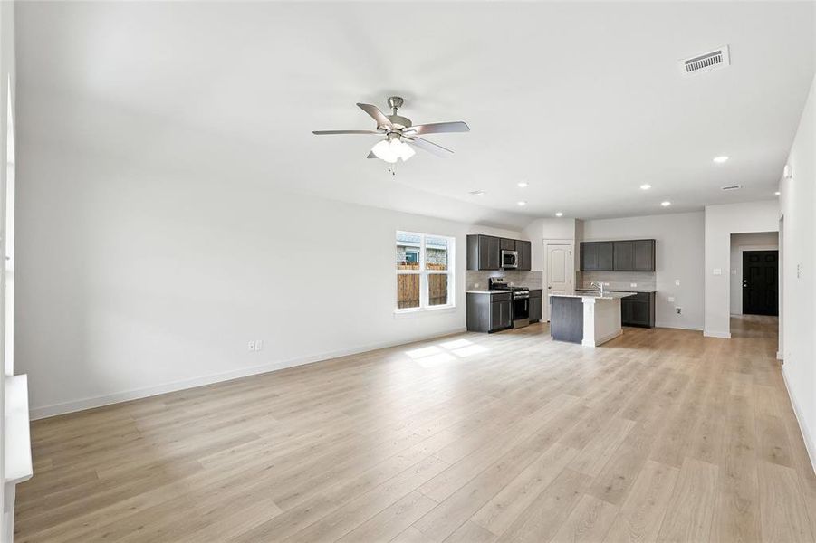 Unfurnished living room with a ceiling fan, recessed lighting, and light wood-type flooring