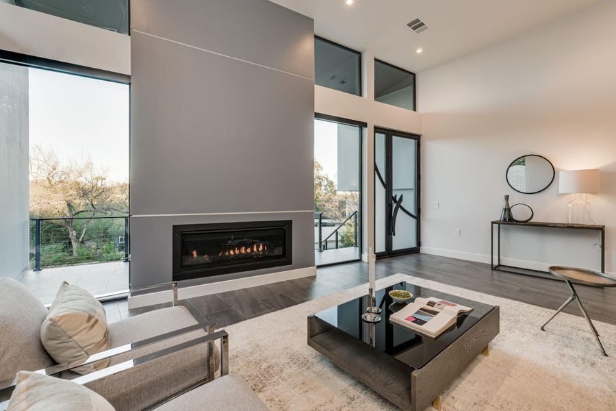 A seamless blend of elegance and innovation, the open living space is anchored by a striking modern linear fireplace, creating a warm yet sophisticated ambiance.