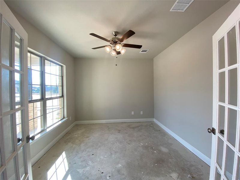 Study with French doors and a ceiling fan.