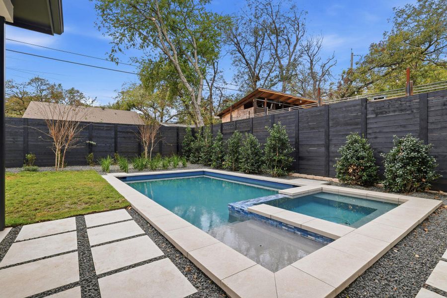 View of swimming pool with a fenced backyard, a pool with connected hot tub, and a patio area