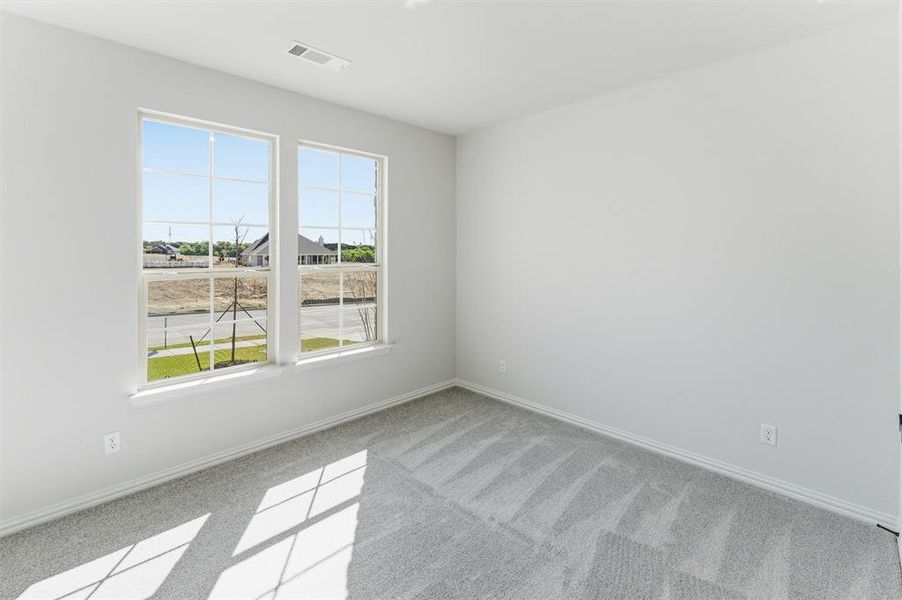 Unfurnished room featuring light carpet and baseboards