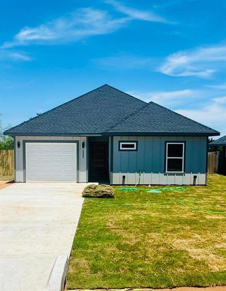 Ranch-style home with a garage and a front yard