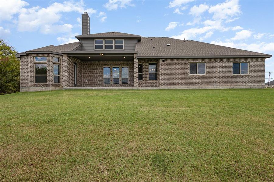 Rear view of property with a lawn