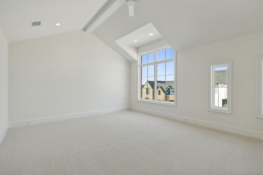 Game room with ceiling fan, plenty of natural light, carpet, and lofted ceiling with beams