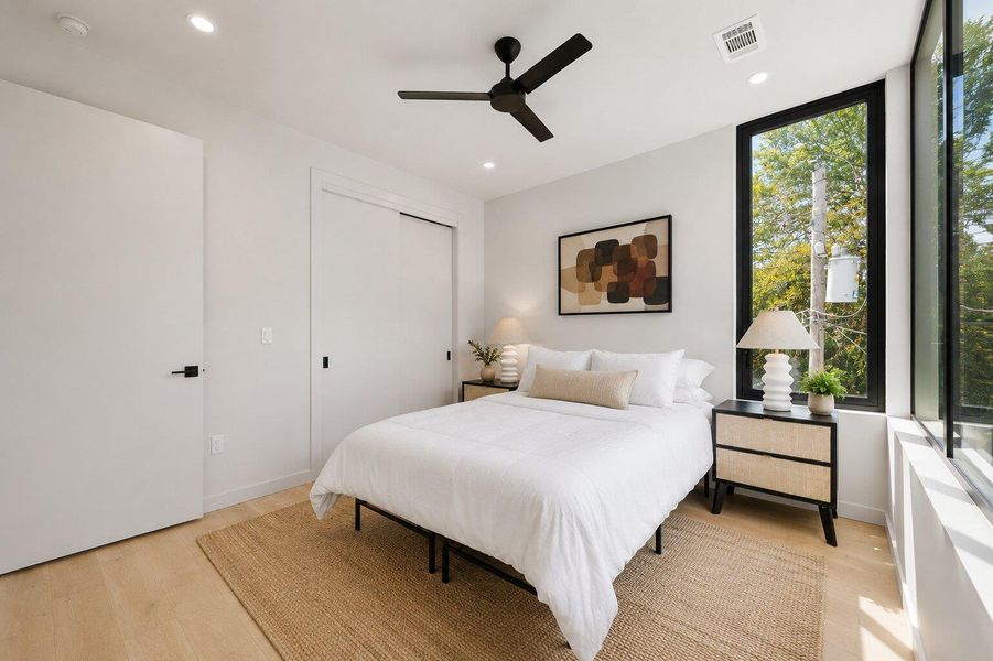 Minimalist design and ample natural light define this cozy primary bedroom. Minimalist design and ample natural light define this cozy primary bedroom.