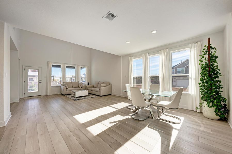 Living area with light wood-type flooring and recessed lighting