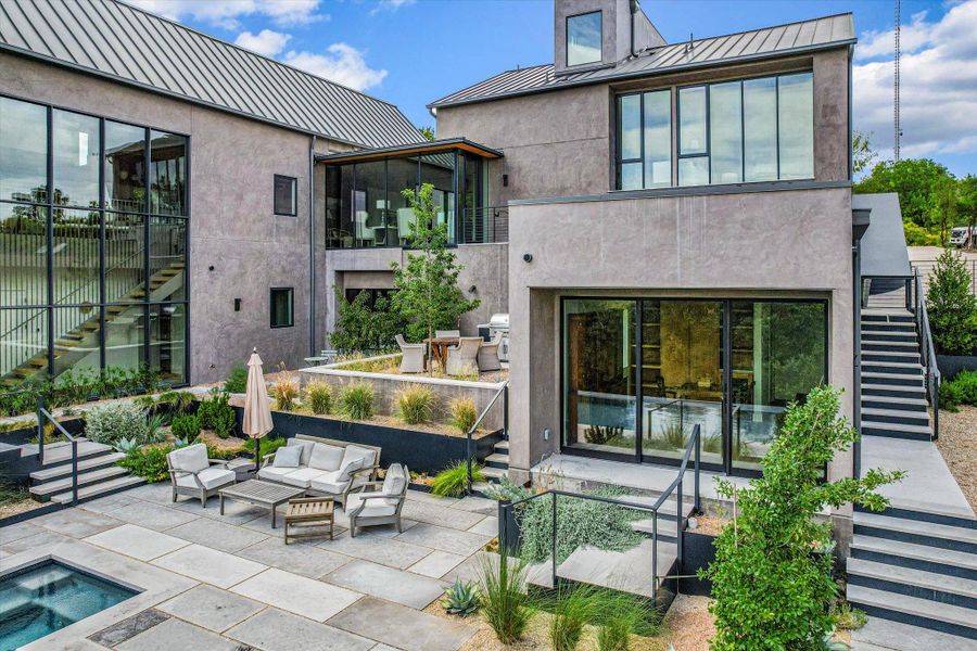 Rear view of property with stairway, a standing seam roof, a patio area, and an outdoor living space