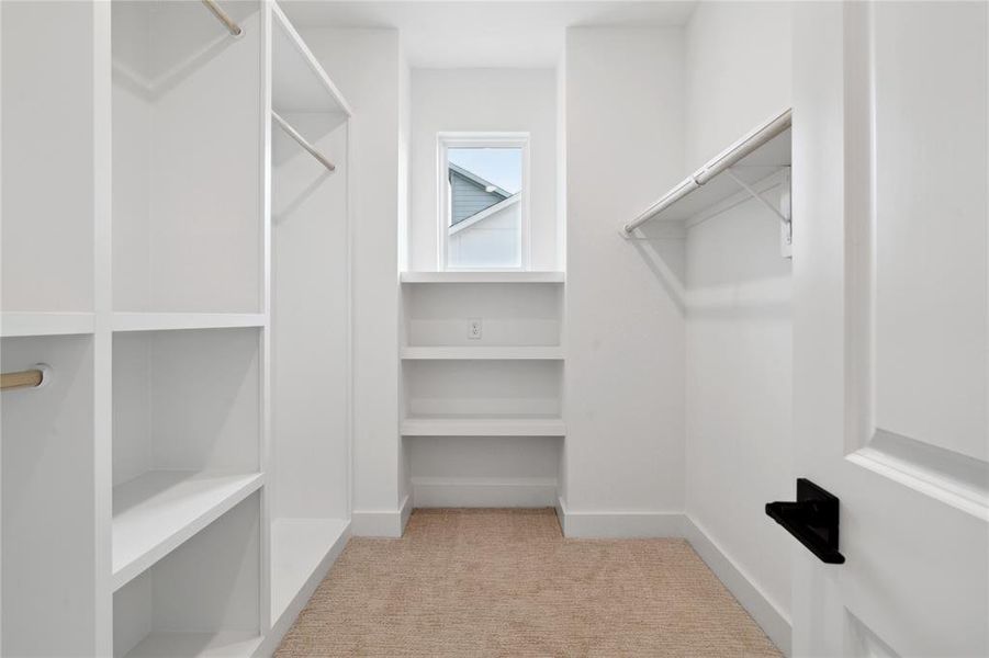 This walk in closet is luxurious in not only it's size but detail with custom shelves for those with a need for organization.