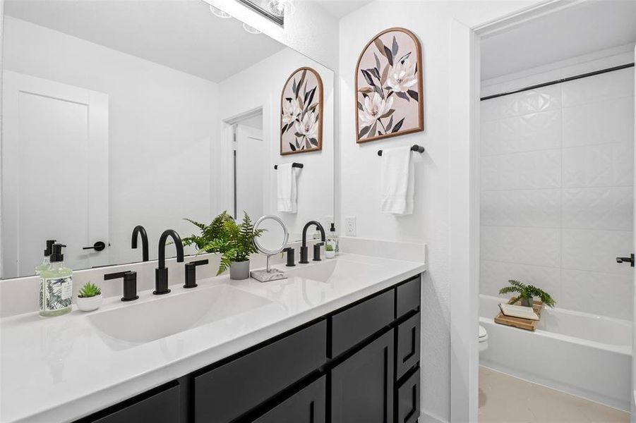 Full bathroom featuring double vanity and shower / bath combo Full bathroom featuring double vanity and shower / bath combo