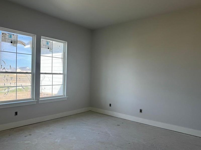 Empty room featuring baseboards and unfinished concrete floors
