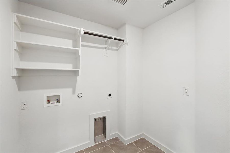 Washroom with hookup for a washing machine, electric dryer hookup, tile patterned flooring, and gas dryer hookup Washroom with hookup for a washing machine, electric dryer hookup, tile patterned flooring, and gas dryer hookup